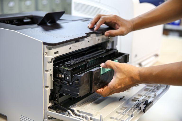 Technician hand open cover printer photocopier or photocopy to replace ink cartridges or fix paper jam for scanning fax or copy document in office workplace.